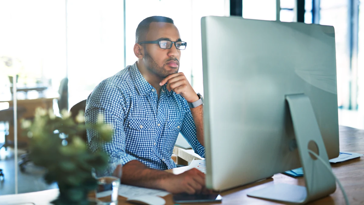 Man looking at desktop screen in office